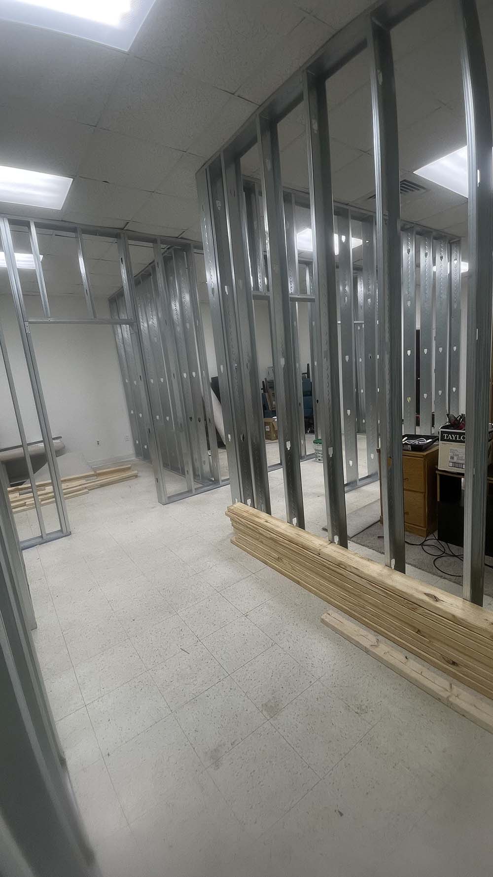 Light gauge steel stud partitions framing office suites and corridor